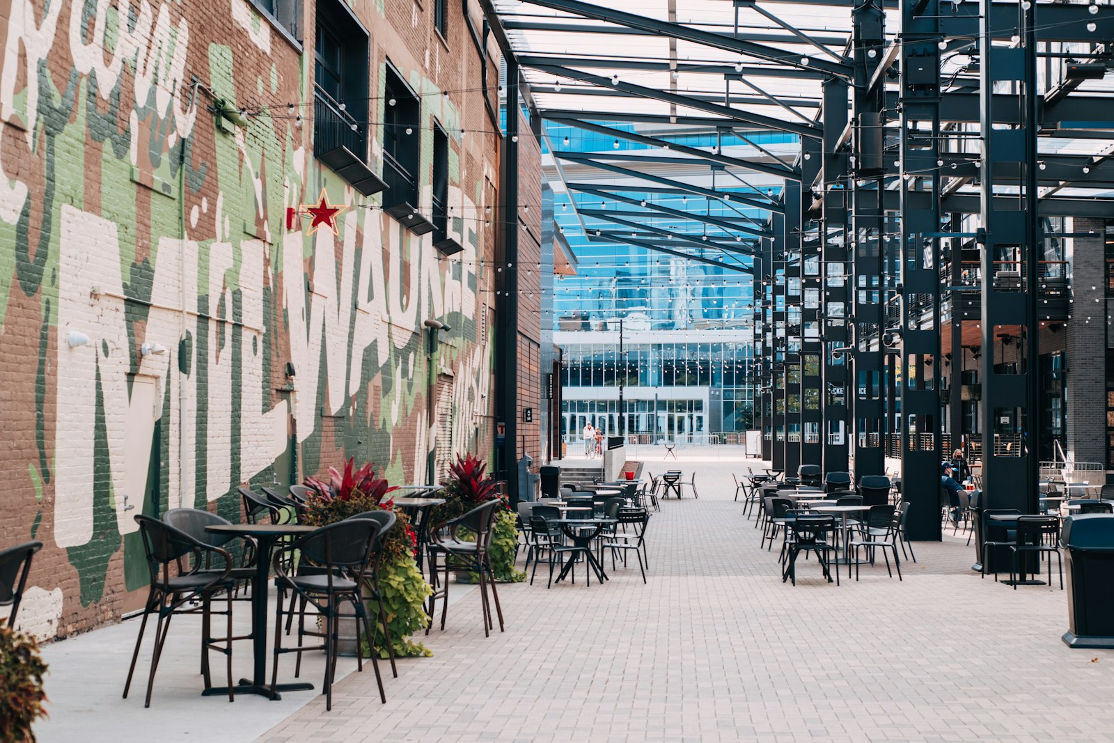 A Milwaukee gathering plaza with a Milwaukee mural and cafe seating